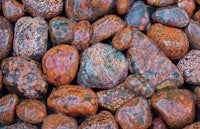 a close up of rocks with red and orange spots