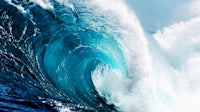 a large blue wave crashing into the ocean